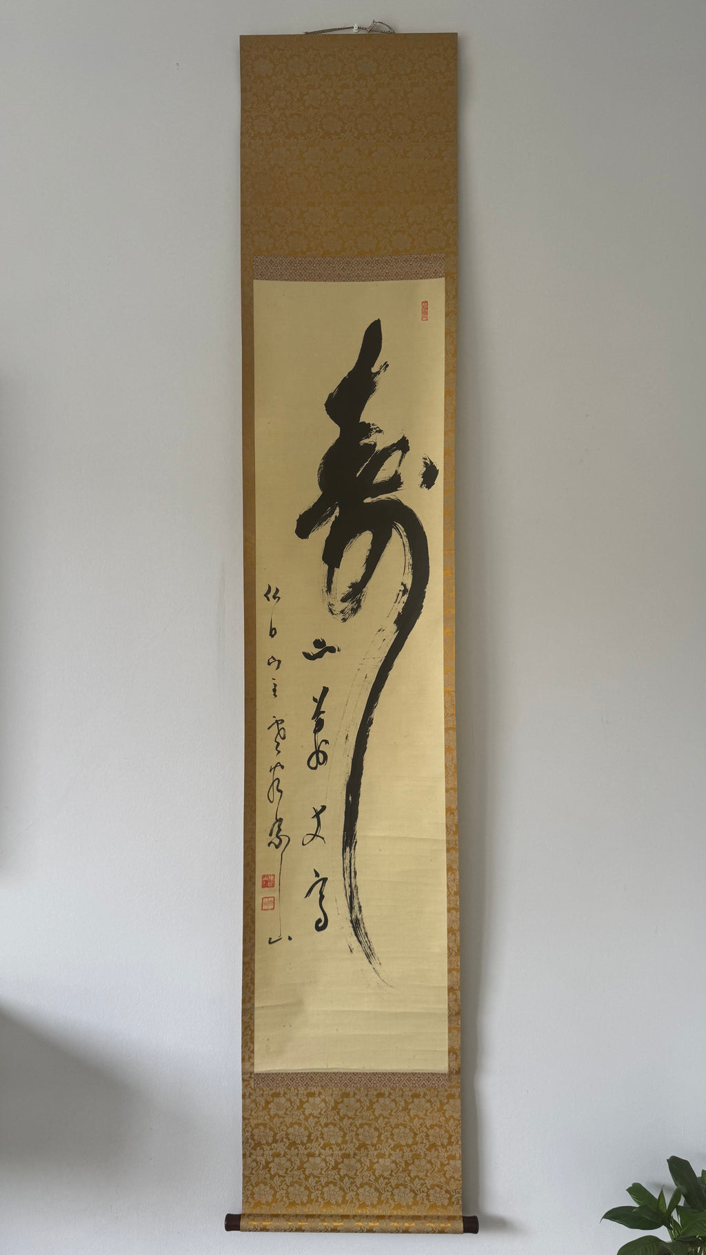 Traditional Japanes calligraphy scroll on a plain wall