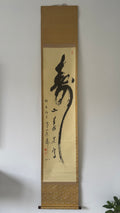 Traditional Japanes calligraphy scroll on a plain wall