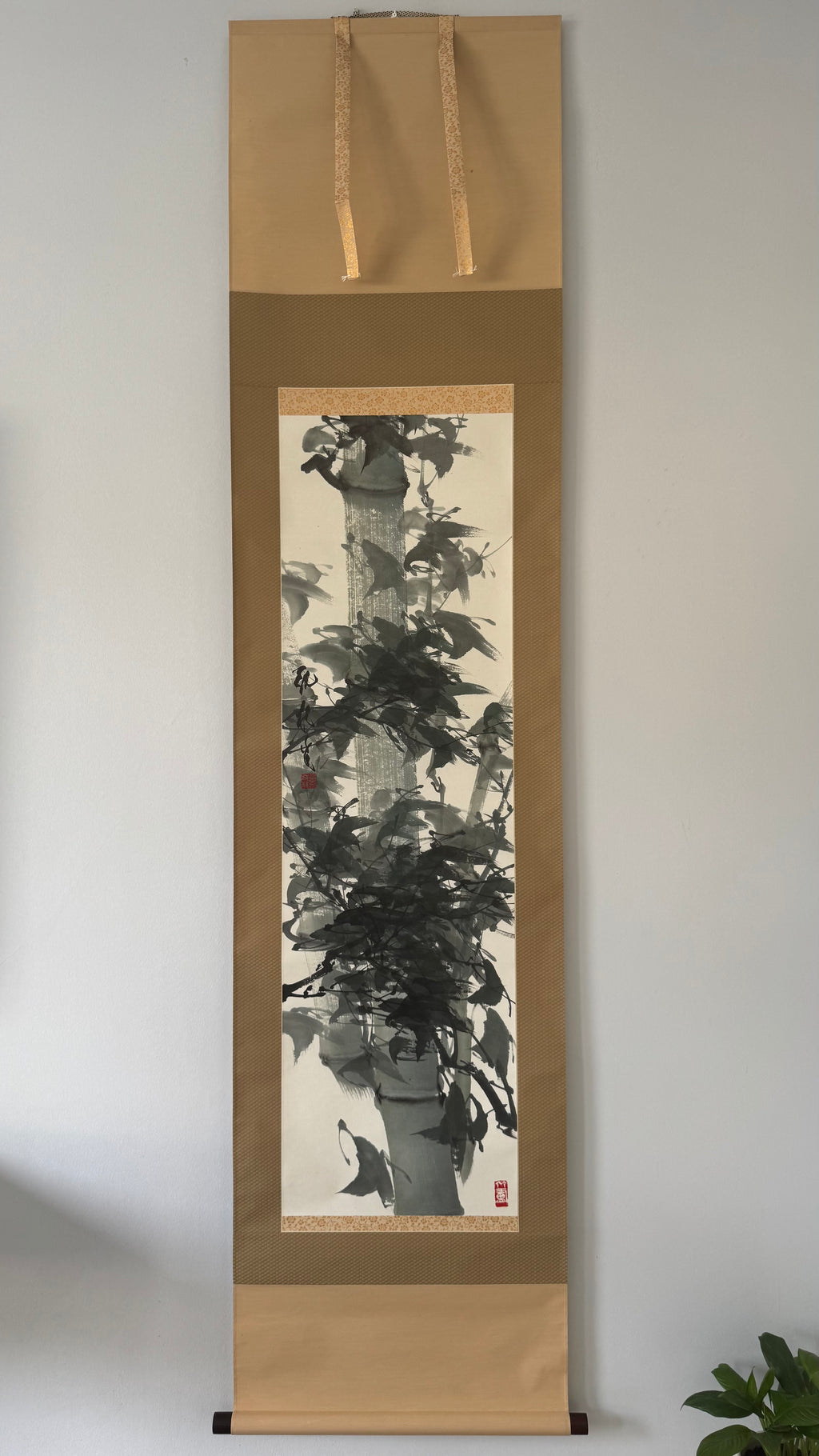 Traditional Japanes painting of a tree on a vertical scroll against a plain background