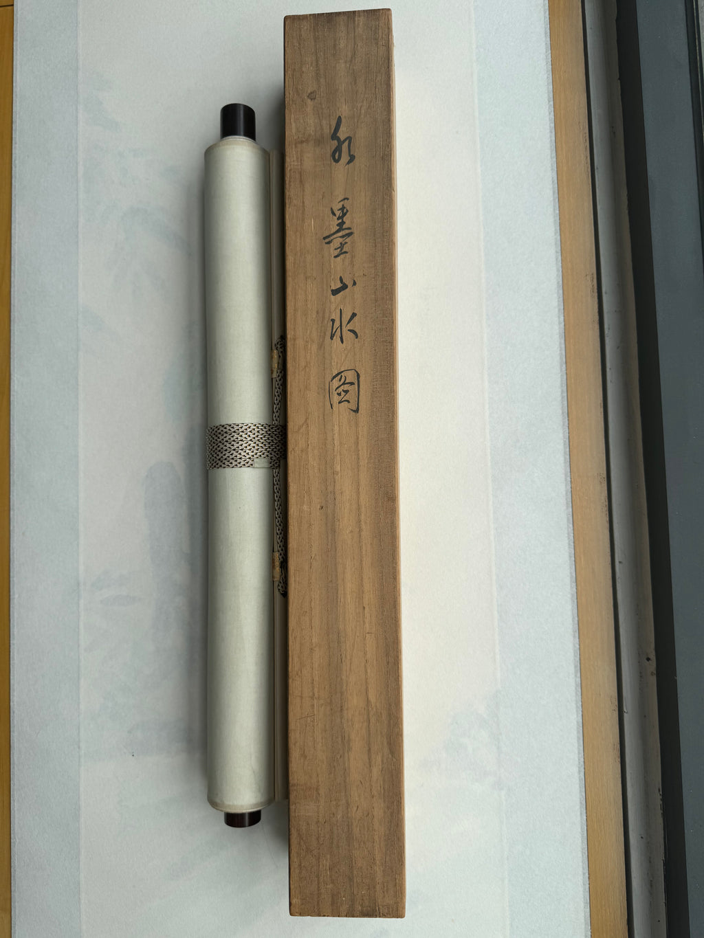 Roll of paper with a wooden box on a textured surface
