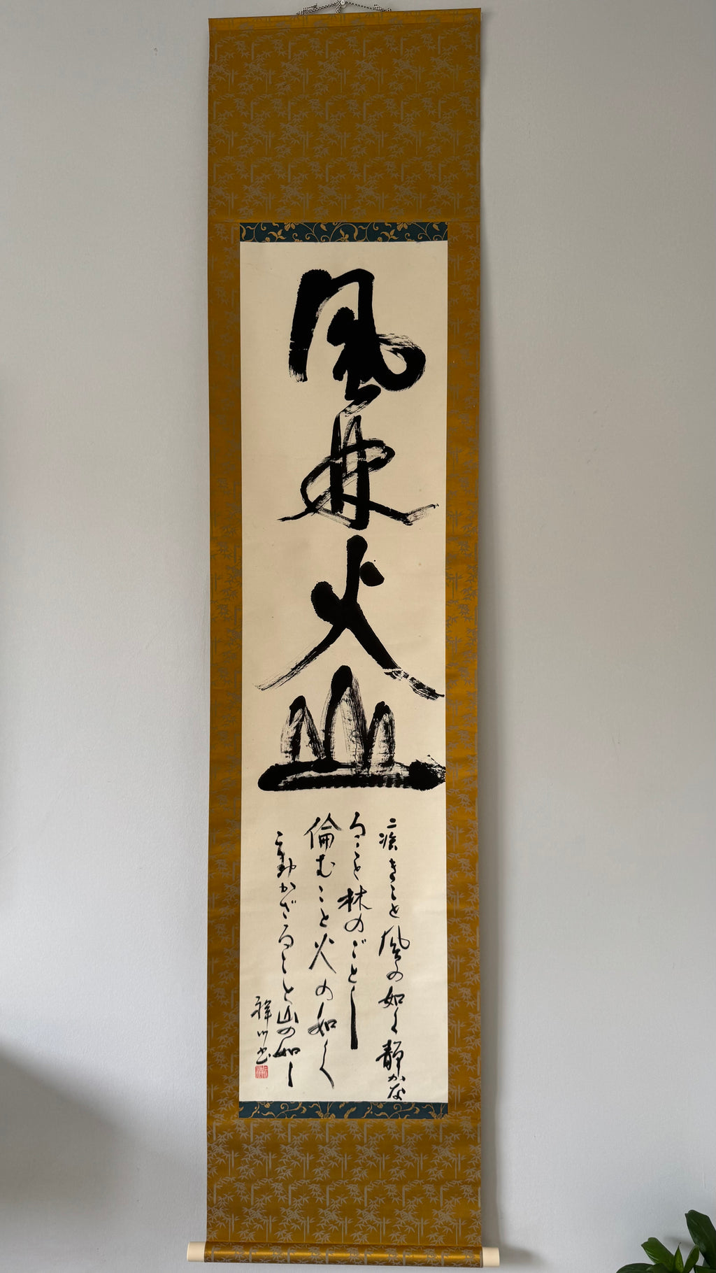Vertical scroll with calligraphy on a plain background
