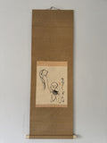 A traditional Japanese hanging scroll (kakemono) featuring a minimalist black ink sketch of a child holding a kite, mounted on a textured brown paper background with a light beige paper insert.