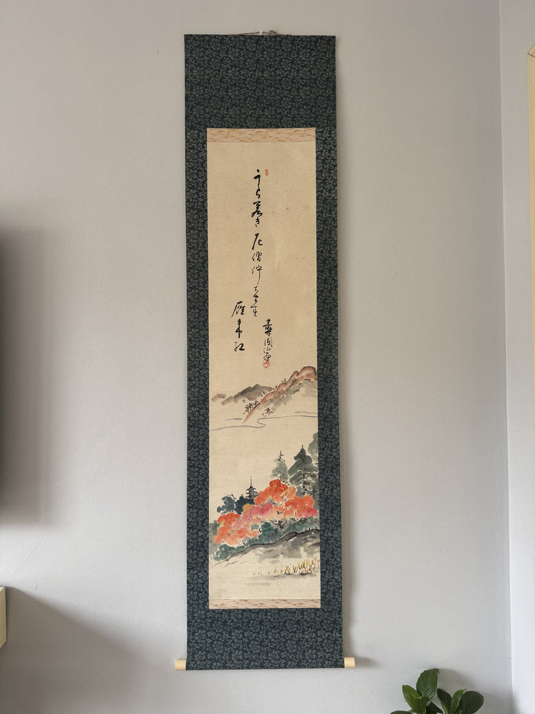 Traditional Japan landscape painting in a black frame on a wall.