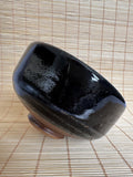 Black ceramic bowl on a woven mat