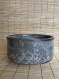 Ceramic bowl with a textured surface on a woven mat background