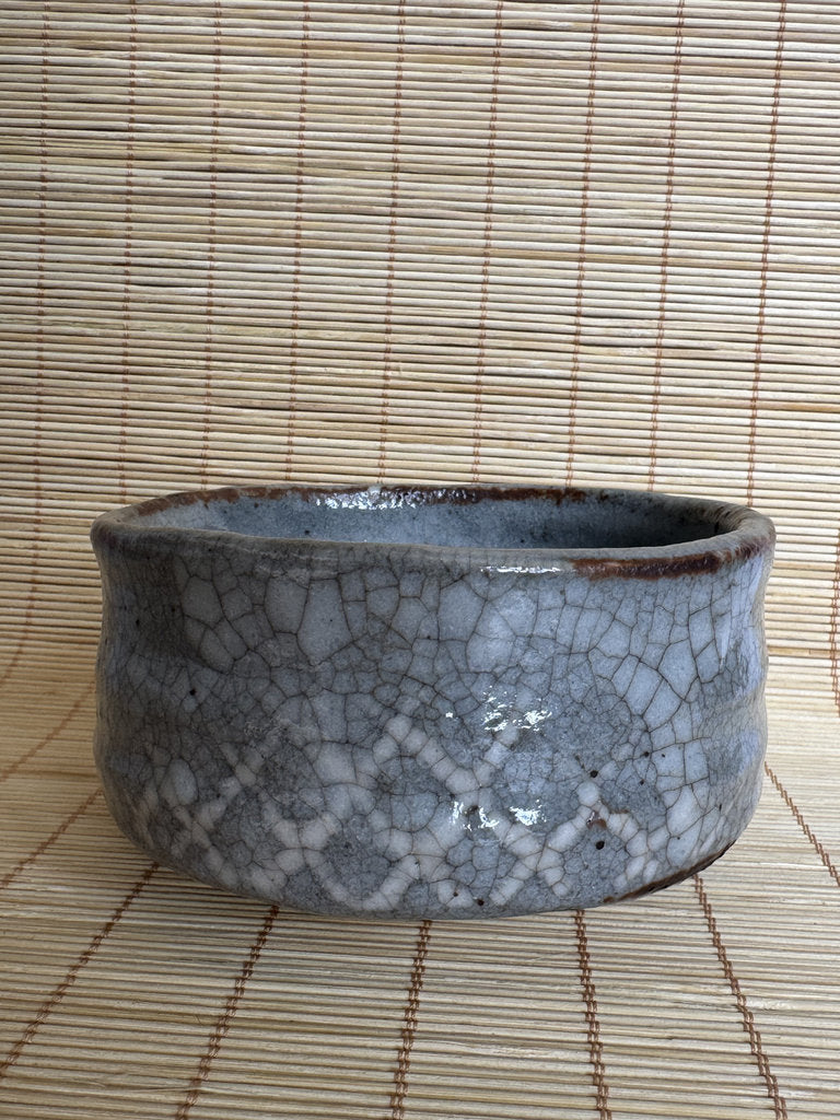 Ceramic bowl with a textured surface on a woven mat background