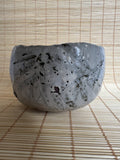 Ceramic bowl with textured surface on a woven mat