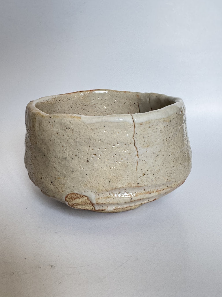 Ceramic bowl with a crack on a light gray background