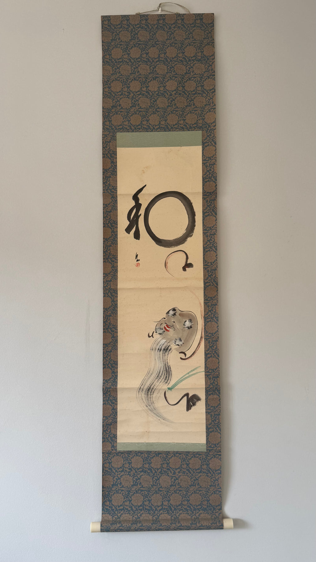 Traditional Japanese scroll with calligraphy and artwork on a plain background