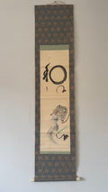 Traditional Japanese scroll with calligraphy and artwork on a plain background