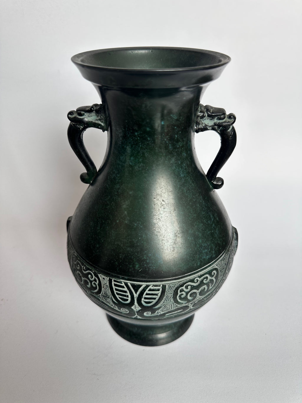 Bronze vase with intricate designs on a white background
