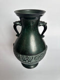 Bronze vase with intricate designs on a white background