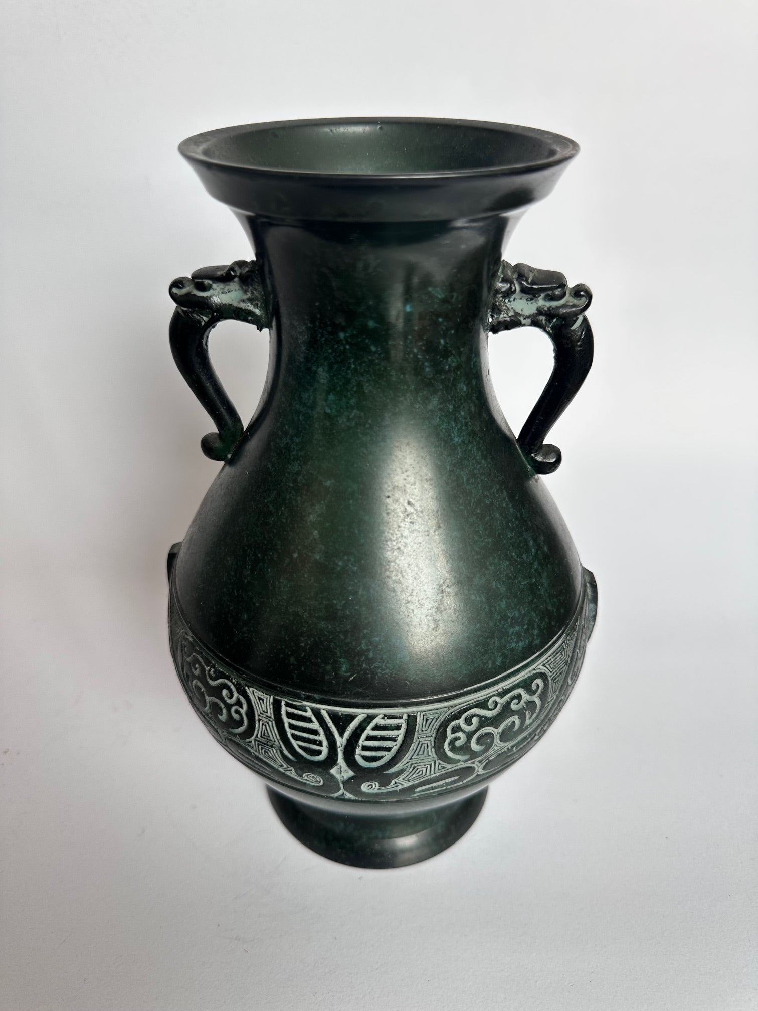 Bronze vase with intricate designs on a white background