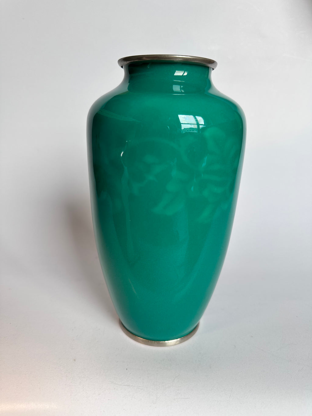 Green vase with floral patterns on a white background