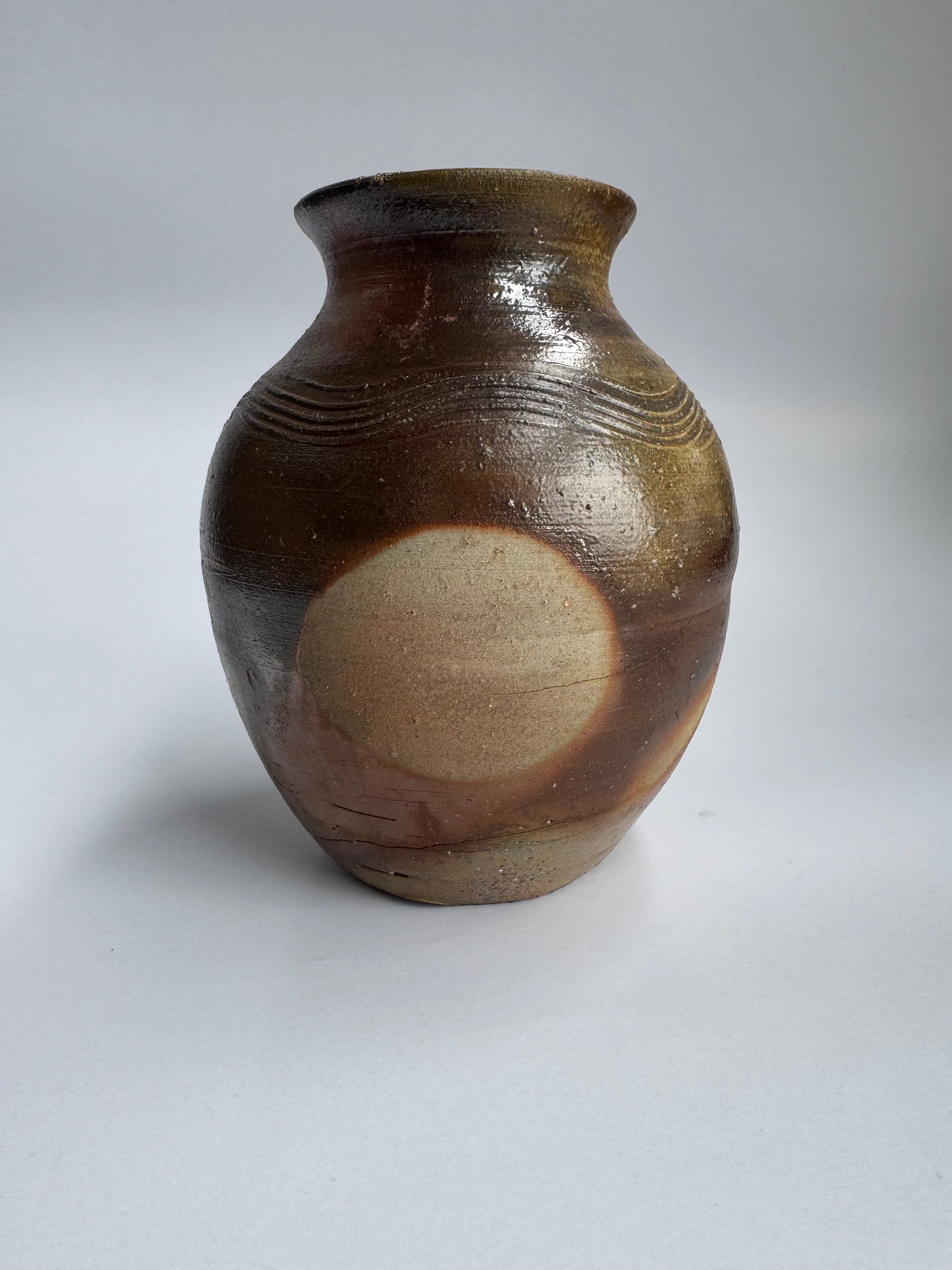 Ceramic vase with brown and beige glaze on a white background