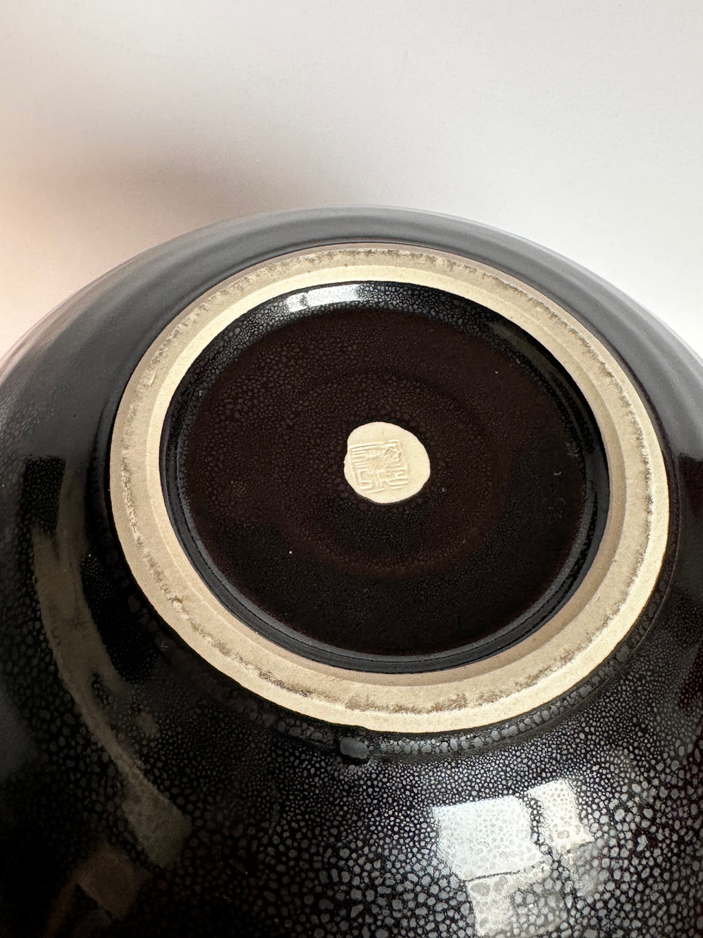 Close-up of a black ceramic bowl with a gold interior