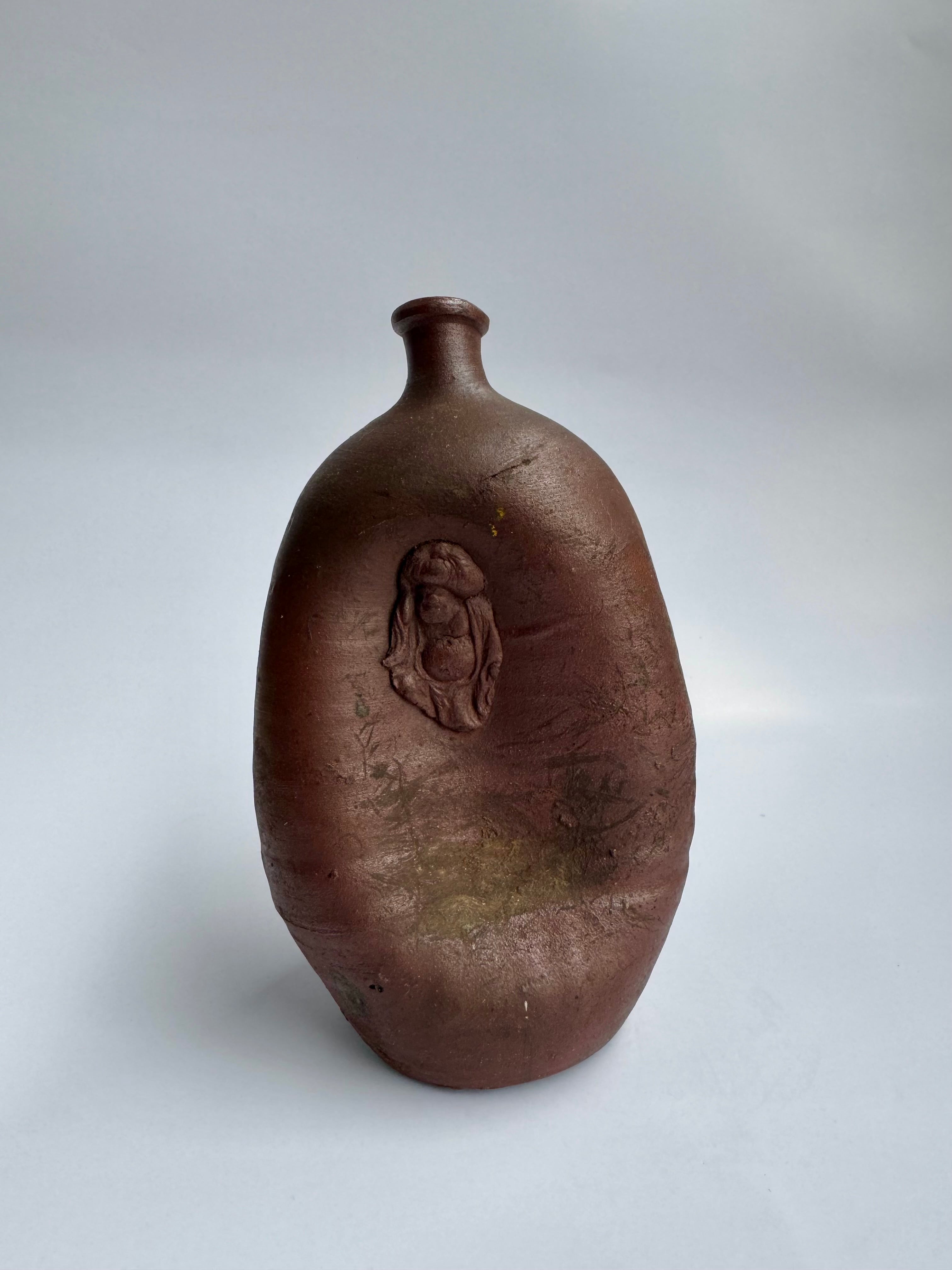 Brown ceramic with a face design on a white background