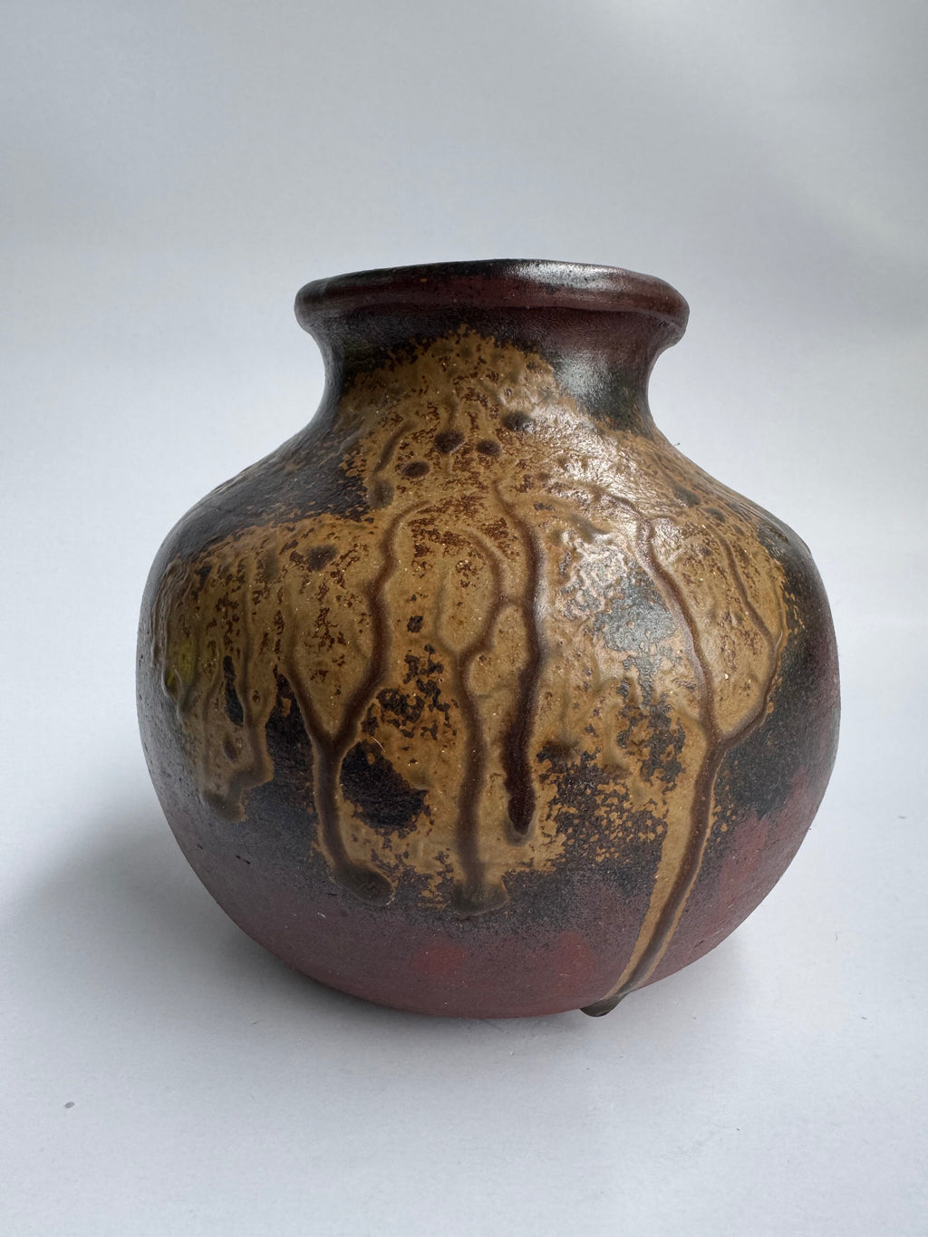 Ceramic vase with brown and black glaze on a white background