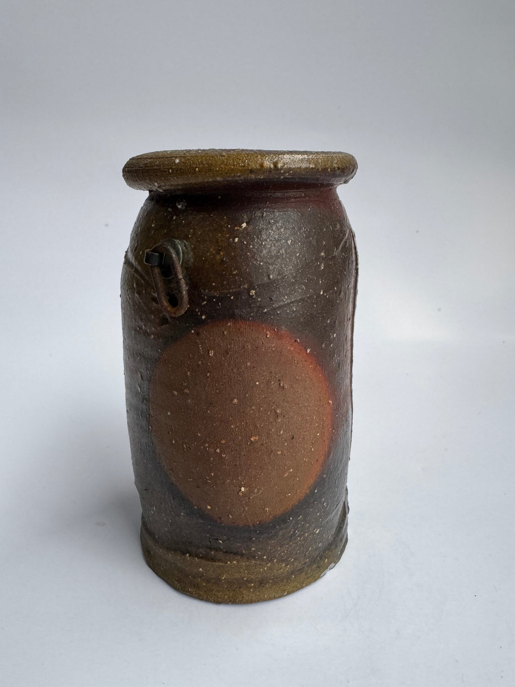 Ceramic jar with brown glaze on a white background