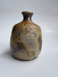 Brown ceramic vase with textured surface on a white background