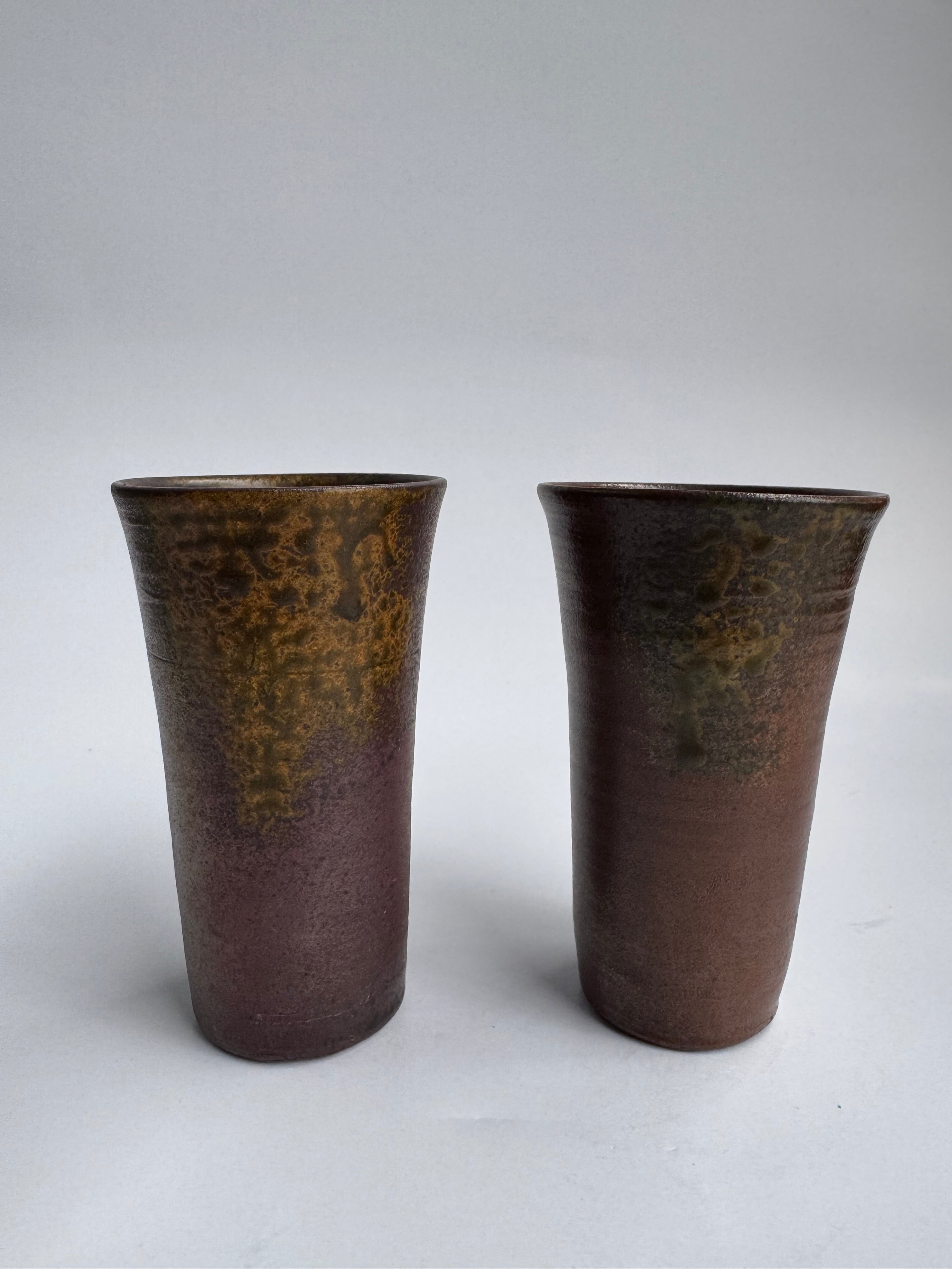 Two brown ceramic cups on a white background