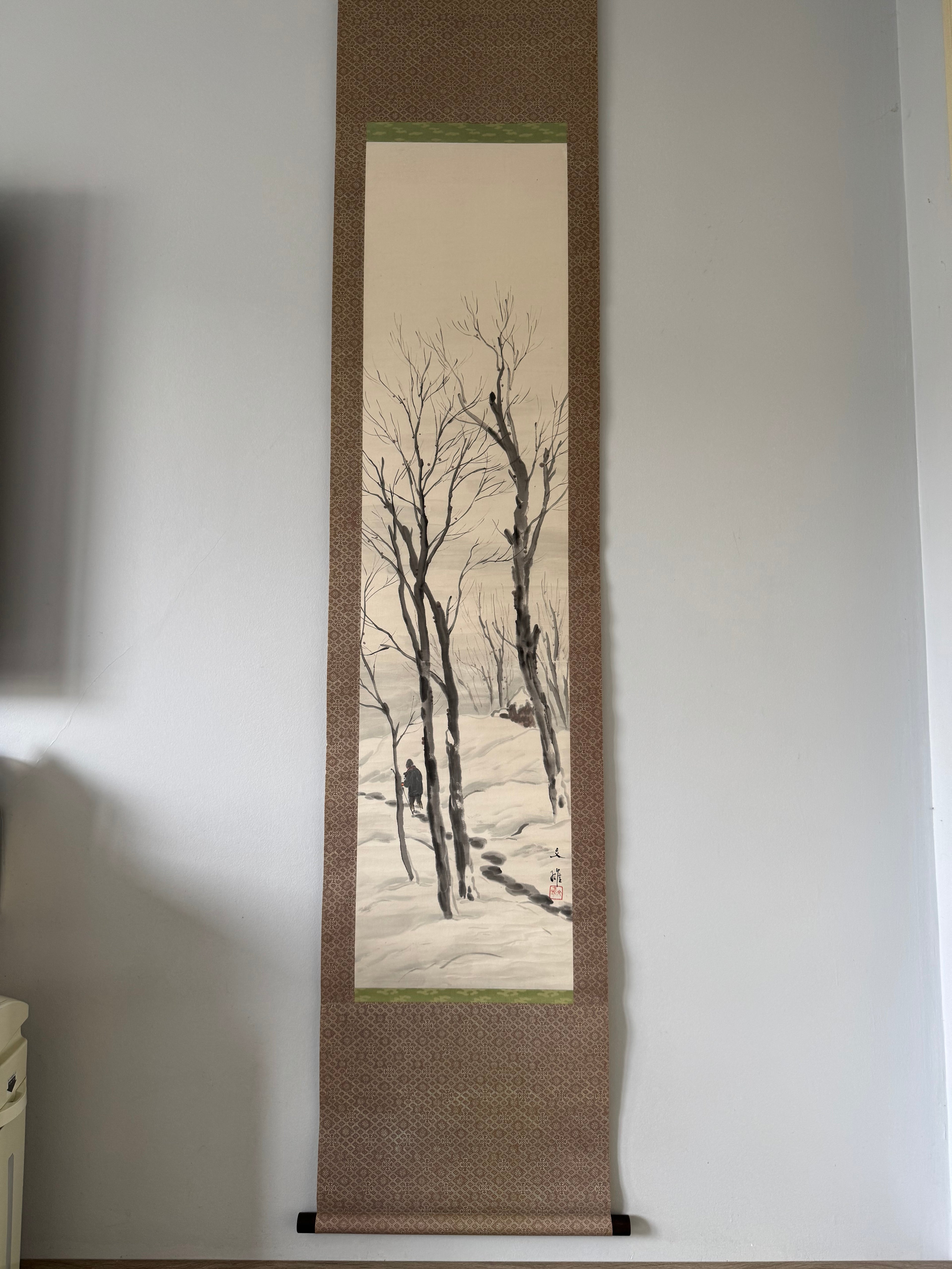Scroll painting of bare branches on a plain wall