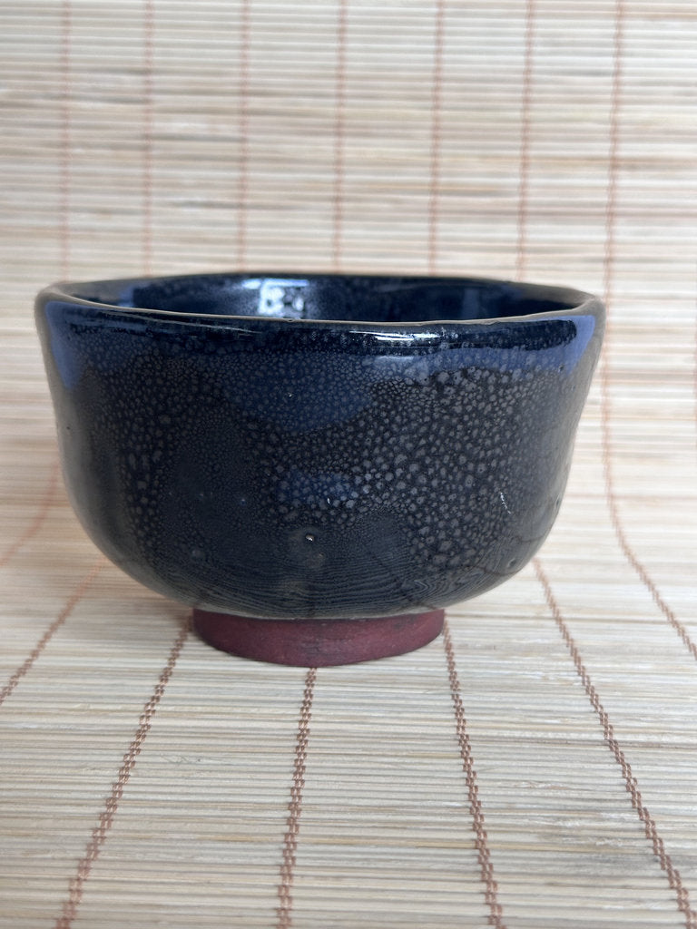 Dark blue ceramic bowl on a woven mat