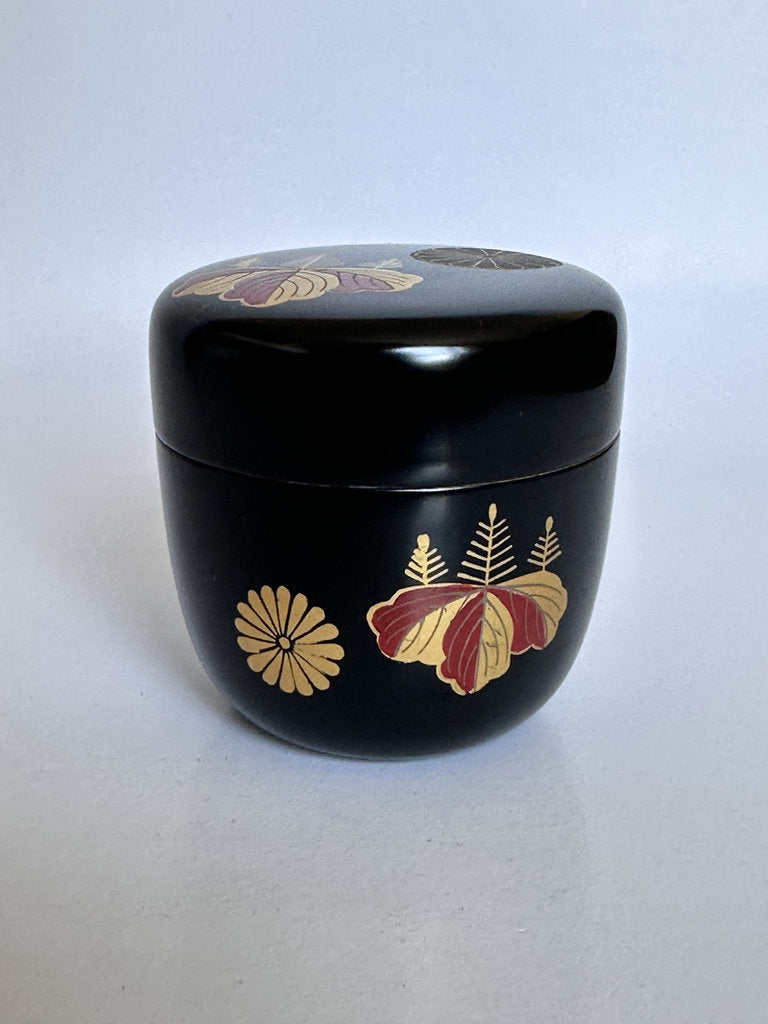 Black container with floral designs on a white background