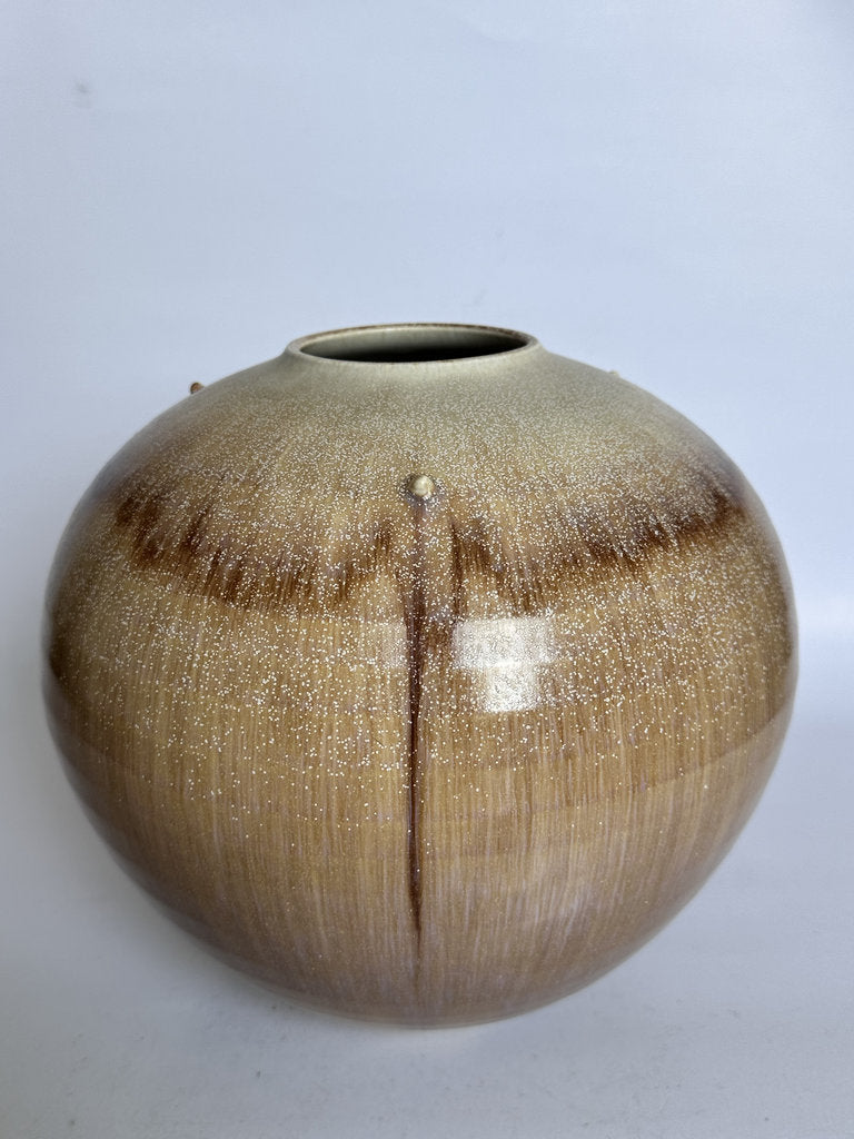 Round ceramic vase with a textured surface on a white background