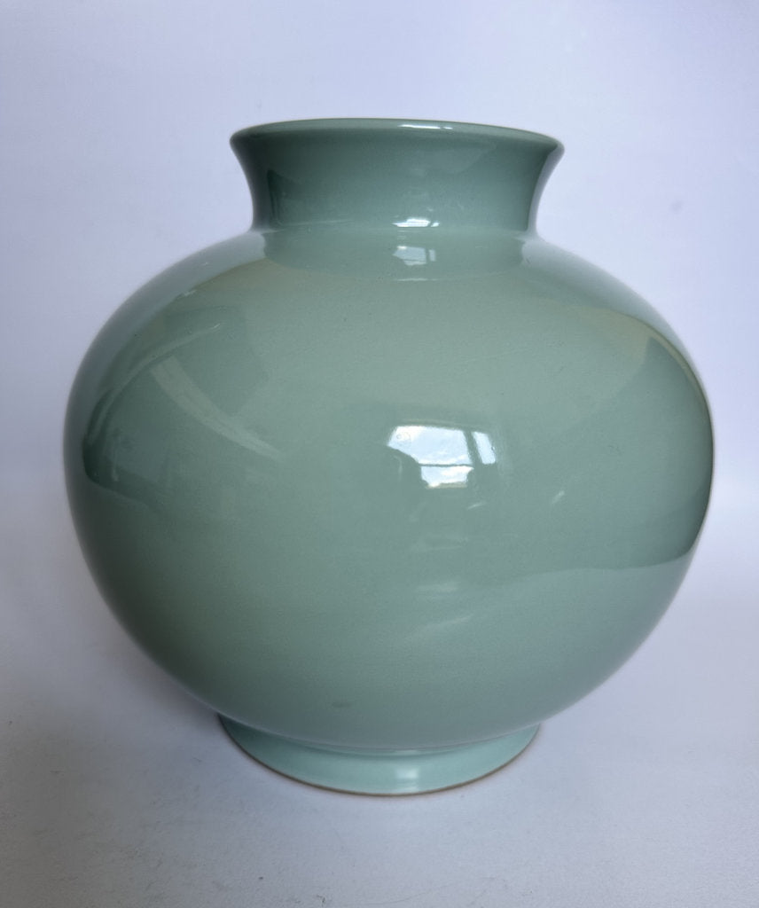 Green ceramic vase on a white background