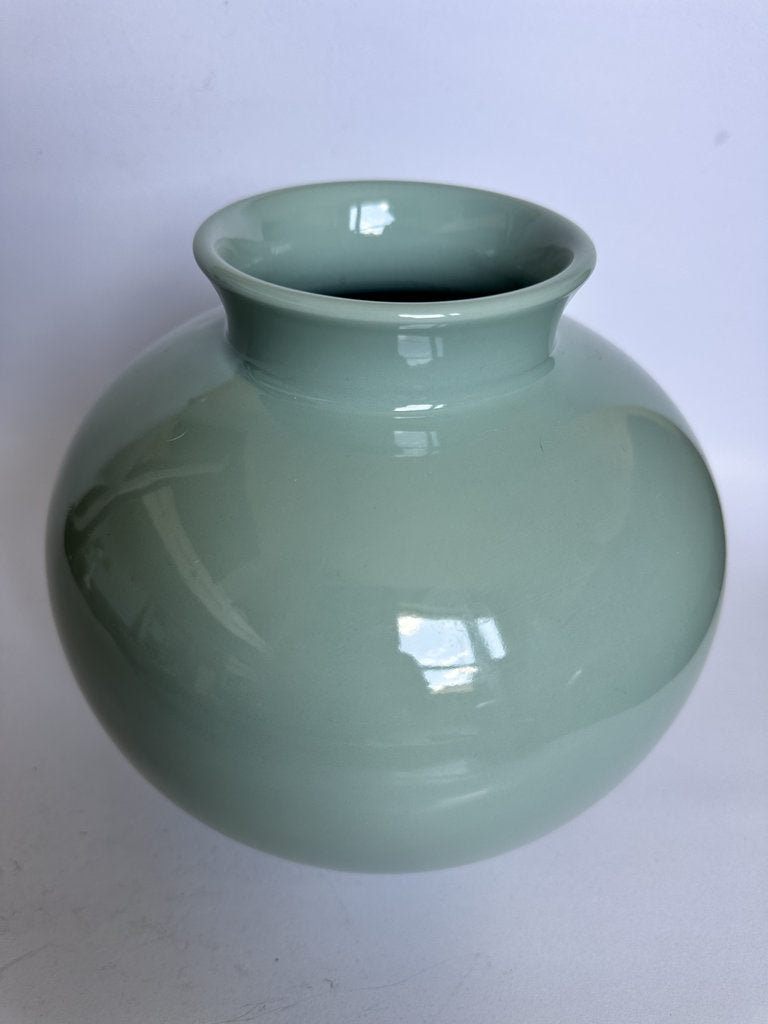 Green ceramic vase on a white background