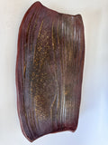 Brown ceramic vase with textured surface on a white background