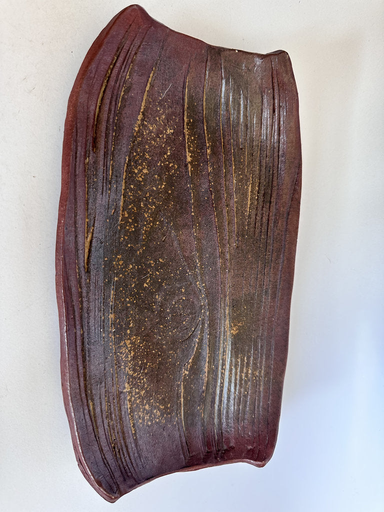 Brown ceramic vase with textured surface on a white background