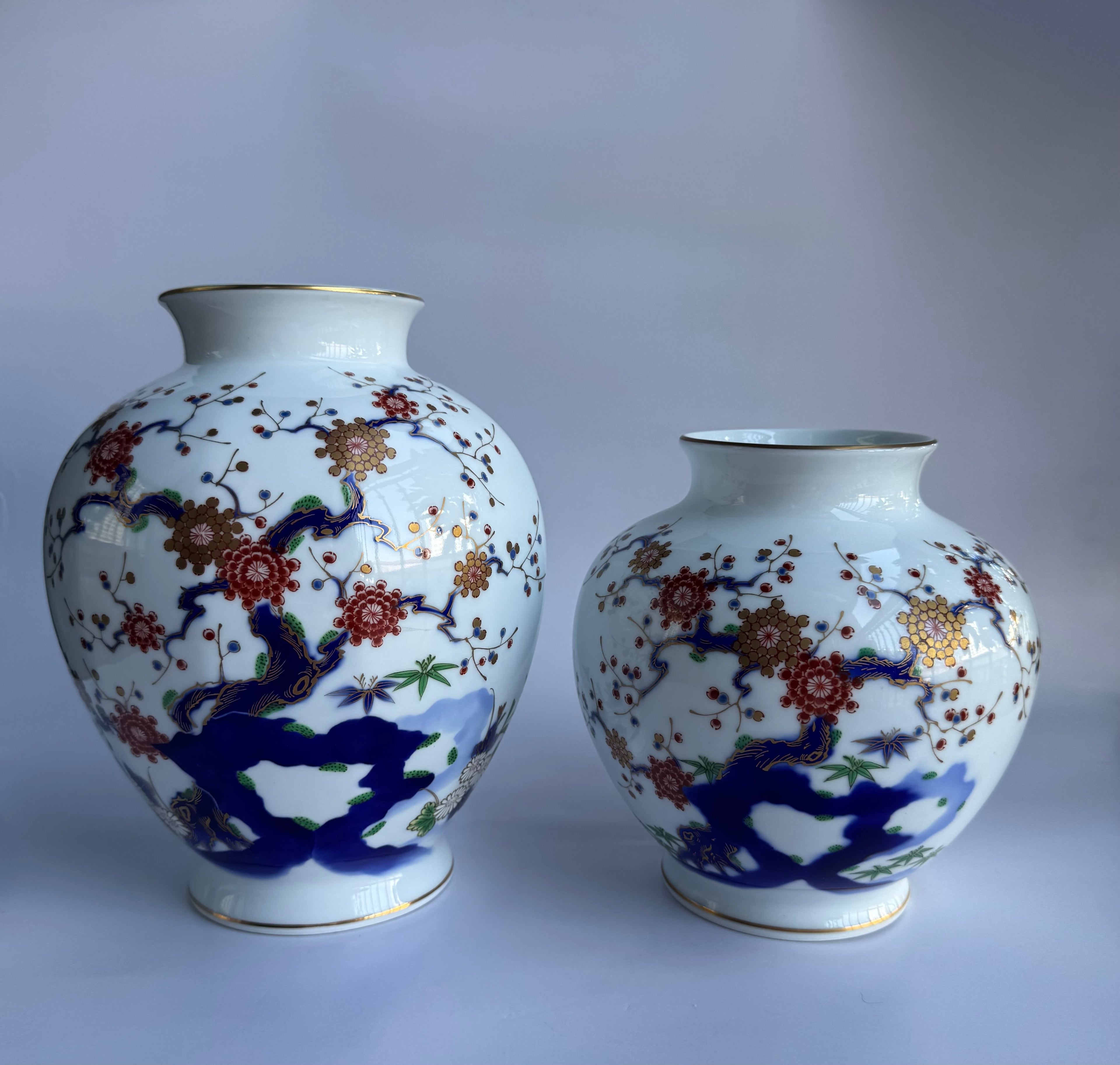 Two ceramic vases with floral patterns on a gray background