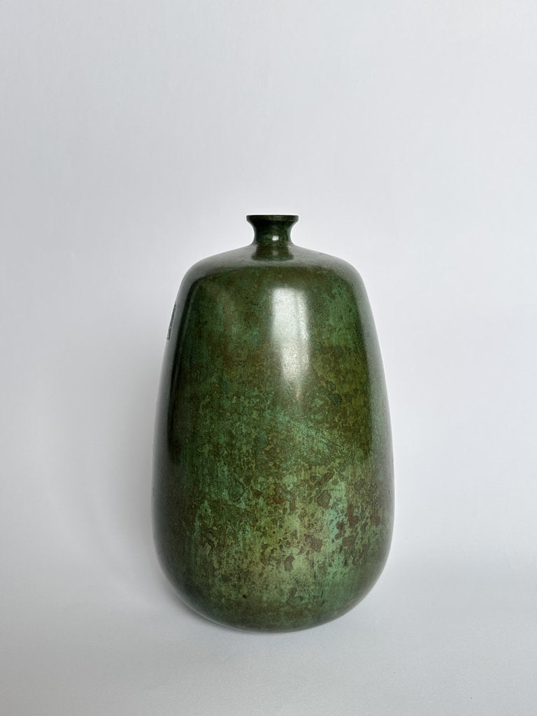 Green bronze vase on a light gray background