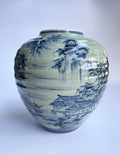Ceramic vase with blue landscape design on a blue background