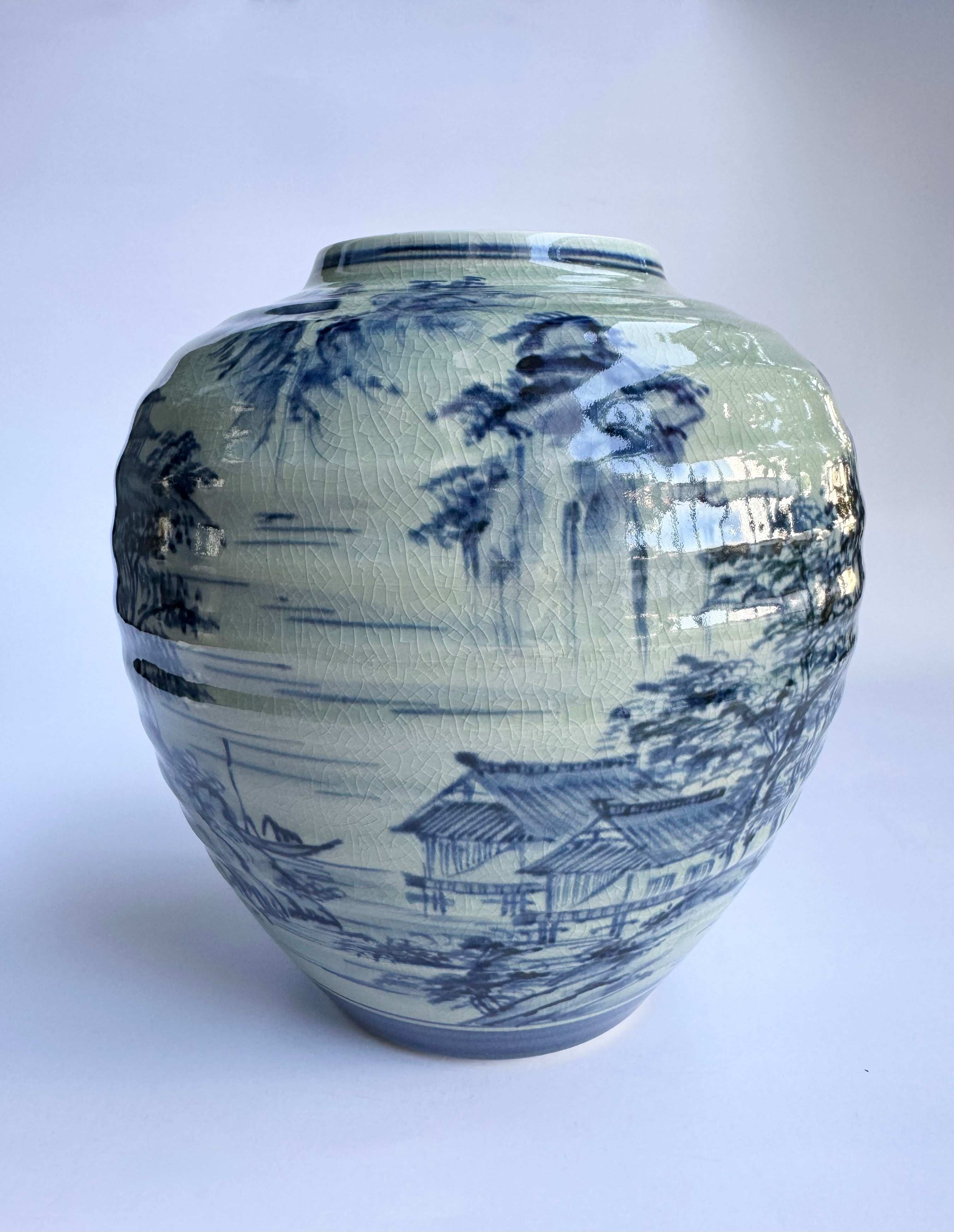 Ceramic vase with blue landscape design on a white background