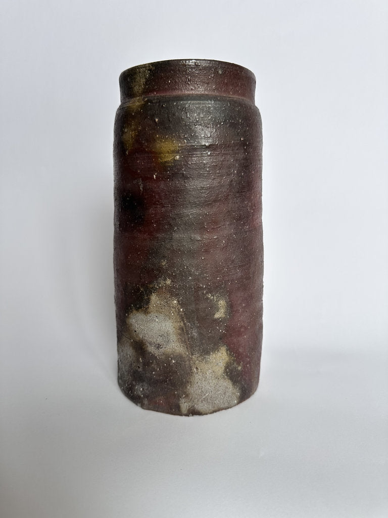 Cylindrical ceramic jar with a textured surface on a white background