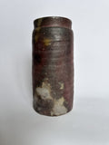 Cylindrical ceramic jar with a textured surface on a white background