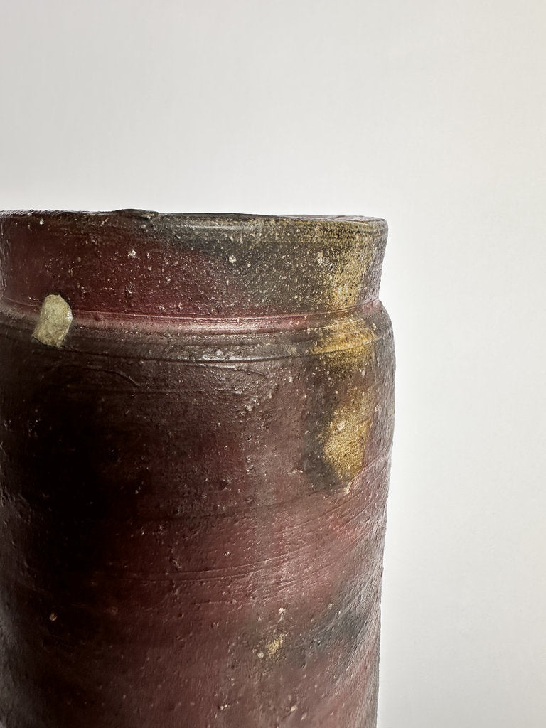 Close-up of a dark brown ceramic vase with a white background