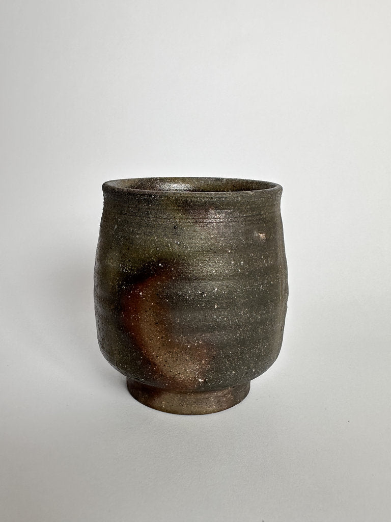 Brown ceramic cup on a light gray background