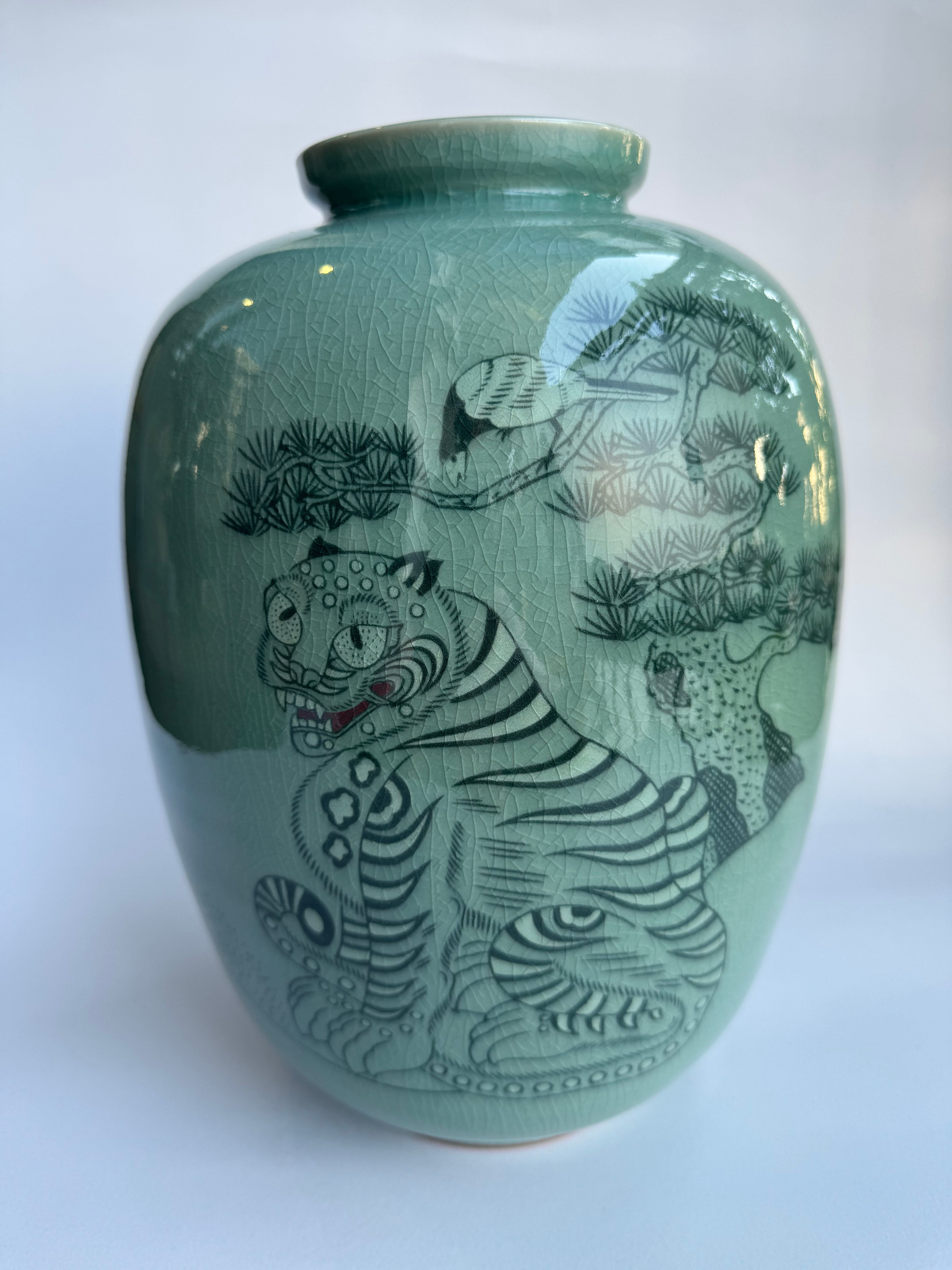 Green ceramic vase with black animal designs 