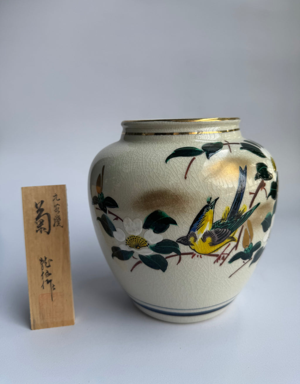 Ceramic vase with bird and floral design on a white background