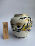 Ceramic vase with bird and floral design on a white background