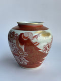 Ceramic vase with red and white floral patterns on a white background