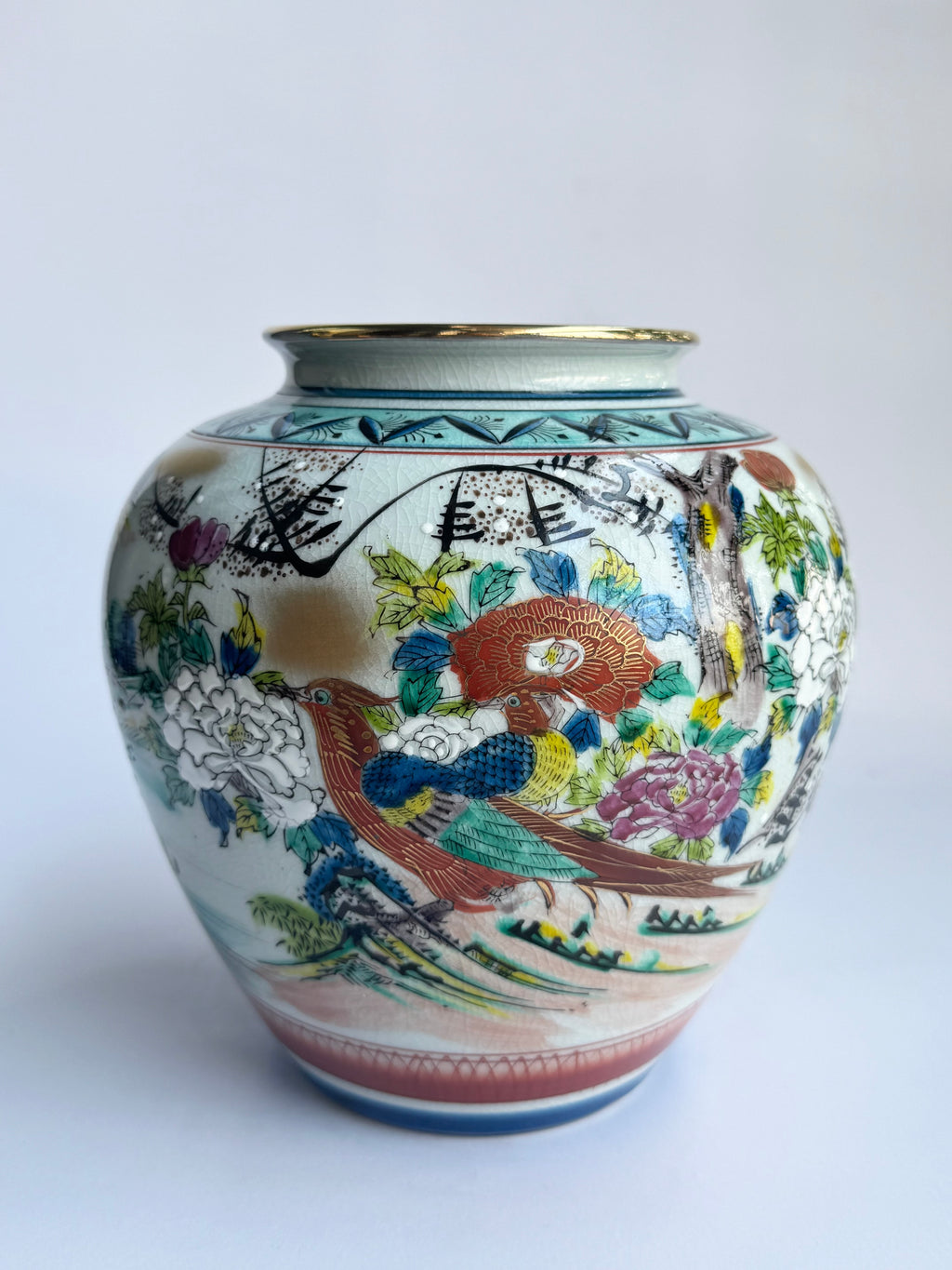 Decorative vase with colorful bird and floral patterns on a white background
