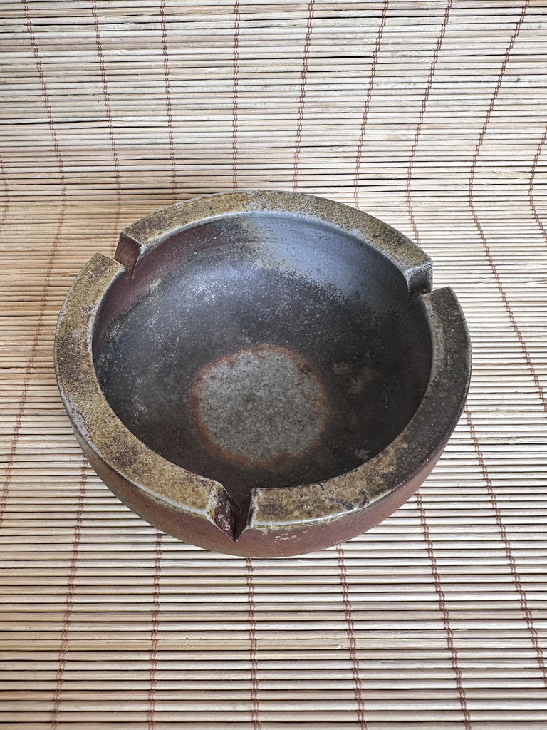 Ceramic ashtray on a woven mat