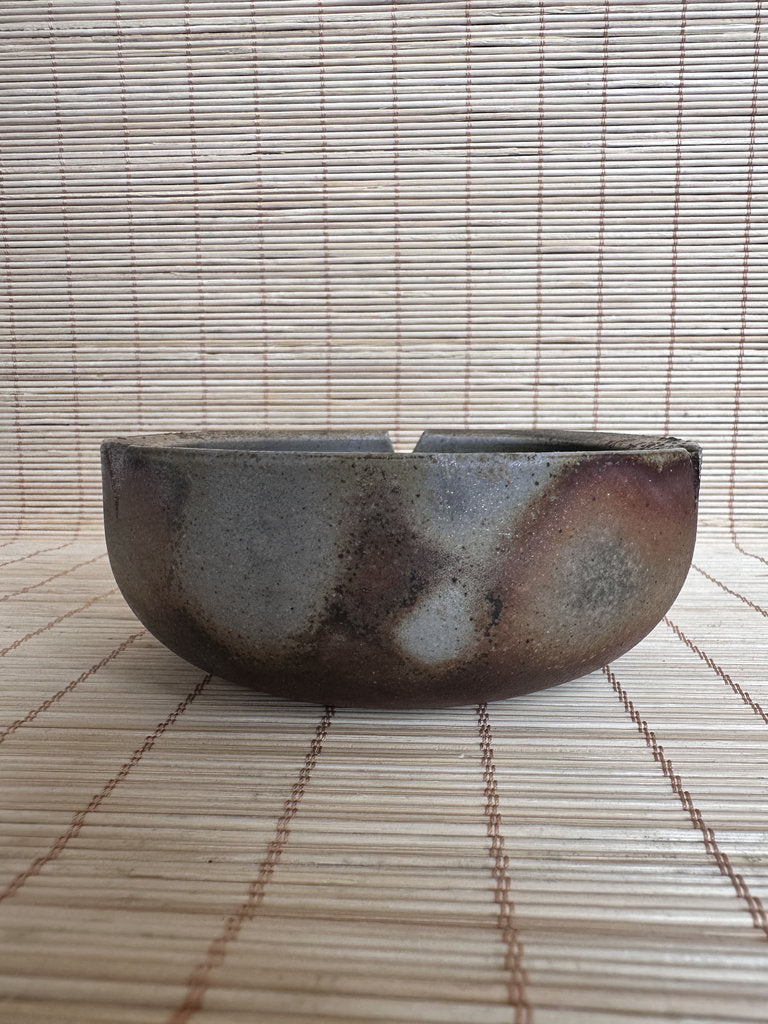 Ceramic bowl with a textured surface on a woven mat
