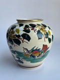 Decorative ceramic vase with floral and bird design on a white background