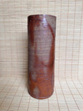 Cylindrical wooden object on a woven mat